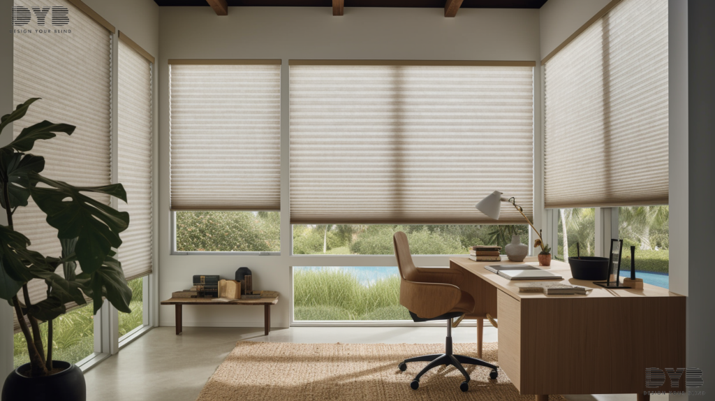 A spacious home office in Lighthouse Point, FL, featuring Honeycomb Shades on a large window with a garden view. The room has a casual coastal design with furniture from Arhaus, including a comfortable desk and chair.